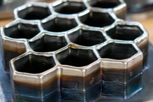 Metal honeycomb structure built up from stacked deposited metal layers, representing automotive applications for laser cladding solutions